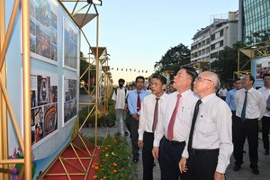 Delegates visit the photo exhibition. (Photo: SGGP)