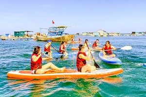 Visitors enjoy the experience of stand-up paddle boarding (SUP) in Phu Quy Island. (Photo: SGGP)