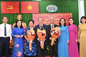 Chairwoman of the HCMC People’s Council Nguyen Thi Le (2nd, L) presents Party membership badges to Party members in District 3 on May 14. (Photo: SGGP)