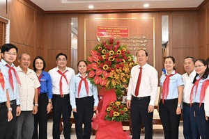 Standing Vice Secretary of the municipal Party Committee Nguyen Ho Hai offers flowers to the Ho Chi Minh Young Pioneer Organization's Council of the city. (Photo: SGGP)