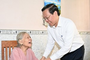 Chairman of the HCMC People’s Committee Phan Van Mai (R) extends 90th birthday greetings to Mrs. Nguyen Thi Bieu. (Photo: SGGP)