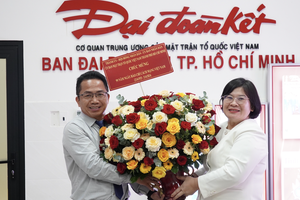 Head of the Organization Committee of the HCMC Party Committee Van Thi Bach Tuyet (R) offers flowers to the representative office of the Dai Doan Ket (Great Unity) Newspaper in HCMC. (Photo: SGGP)