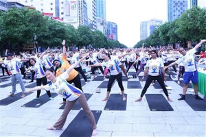 1,500 yogis perform yoga postures together in District 1, HCMC on the 10th International Yoga Day (Photo: VNA)