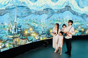 Visitors enjoy masterpieces at the digital exhibition, "Van Gogh & Monet Art Lighting Experience". (Photo: SGGP)