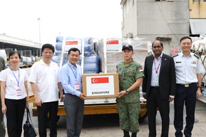 Representatives of the Ministry of Agriculture and Rural Development receive emergency relief supplies from the Singaporean government. (Photo: SGGP)