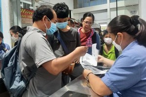 Passengers buy train tickets at a station. (Photo: SGGP)