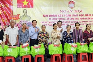 Chairman of the HCMC People's Committee Phan Van Mai offers presents to poor households. (Photo: SGGP)