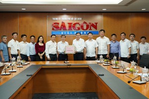 The delegation of the Propaganda and Education Board of the Party Committee of Nghe An Province offers a gift to the Sai Gon Giai Phong Newspaper. (Photo: SGGP)
