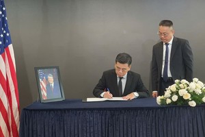 Vice Chairman of the Ho Chi Minh City People’s Committee Nguyen Van Dung writes in the condolence book for late former President Jimmy Carter. at the U.S. Consulate General in the city. (Photo: SGGP)
