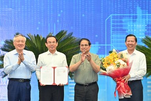 PM Pham Minh Chinh (second from right) presents the Decision approving HCM City's master planning scheme to its leaders. (Photo: SGGP)