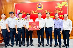 Vice Secretary of the Ho Chi Minh City Party Committee Nguyen Phuoc Loc (4th, R) and Vice Chairman of the municipal People’s Committee Bui Xuan Cuong (3rd, R) offer Tet gifts to the Command of Naval Region 2. (Photo: SGGP)