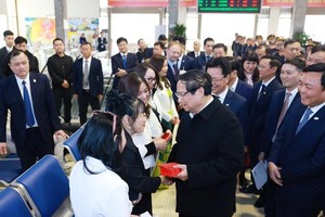 Prime Minister Pham Minh Chinh presents lucky money to passengers at the Hanoi Railway Station. (Photo: VNA)