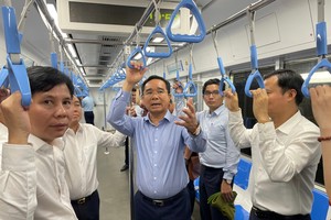 Chairman of Ho Chi Minh City People's Committee, Nguyen Van Duoc (C) and his delegation ride Ben Thanh-Suoi Tien metro line before having a working session with the Management Authority for Urban Railways (MAUR) on March 4. (Photo: SGGP)