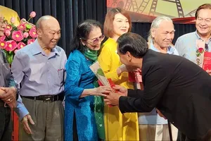 Actor Quyen Linh presents commemorative medals to the veteran artists. (Photo: SGGP)