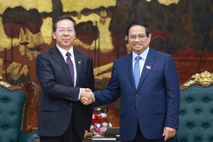 Prime Minister Pham Minh Chinh (R) receives Peng Gangping, Chairman of China Huadian Engineering Co., Ltd. (Photo: VNA)