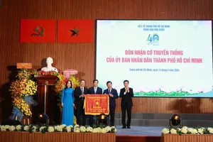 Vice Chairman of the Ho Chi Minh City People’s Committee Nguyen Van Dung (R) presents a traditional flag to Ho Chi Minh City Oncology Hospital in recognition of its achievements in construction and development. (Photo: SGGP)