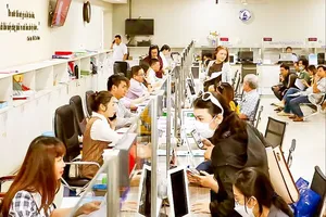 Civil servants and public employees of the People’s Committee of District 12 in Ho Chi Minh City are receiving and processing administrative procedures for residents. (Photo: SGGP)