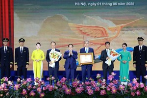 Prime Minister Pham Minh Chinh awards a certificate of merit to Vietnam Airlines. (Photo: VNA)