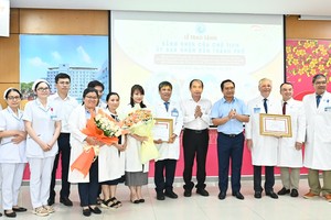 Chairman of the Ho Chi Minh City People's Committee Nguyen Van Duoc (6th,R) and Director of the Ho Chi Minh City Department of Health Tang Chi Thuong (7th,R) offer flowers and certificates of merit to healthcare professionals of Children's Hospital 1 and Tu Du Obstetrics Hospital. (Photo: SGGP)