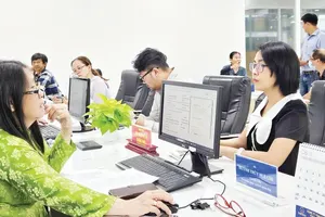 Civil servants at the Xuan Hoa Ward's Public Administration Service Center process administrative procedures for a resident via the National Public Service Portal. (Photo: SGGP)