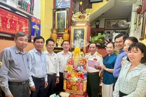 Standing Vice Chairman of the Ho Chi Minh City People's Council, Pham Thanh Kien offers a gift to Mr. Nguyen Hung Tanh. (Photo: SGGP)