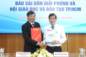 Deputy Editor-in-Chief in charge of SGGP Newspaper, journalist Nguyen Khac Van (R), and Associate Professor Dr. Nguyen Kim Hong sign a memorandum of understanding to strengthen cooperation in the fields of education and training. (Photo: SGGP)