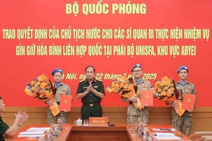 Senior Lieutenant General Phung Si Tan (second from left), Deputy Chief of the General Staff, presents decisions of the State President and the Minister of National Defence to three officers who are about to depart for duties at the UN peacekeeping mission in Abyei. (Photo: VNA)