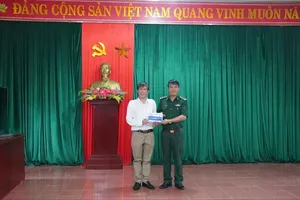 Deputy Editor-in-Chief in charge of SGGP Newspaper, journalist Nguyen Khac Van (L) presents 30 scholarships to students facing difficult circumstances in the central province of Quang Tri on July 27. (Photo: SGGP)