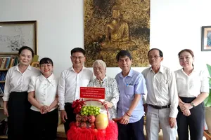 Head of the Propaganda and Mass Mobilization Commission of the Ho Chi Minh City Party Committee Nguyen Manh Cuong (3rd, L) and the city's officials visit writer Xuan Phuong (4th, R). (Photo: SGGP)