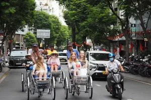 Foreign tourists enjoy cyclo rides along Truong Dinh Street in Ben Thanh Ward, Ho Chi Minh City. (Photo: SGGP)