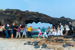 Visitors capture photographs in front of the iconic To Vo Gate, a renowned natural landmark in the Ly Son Special Zone.