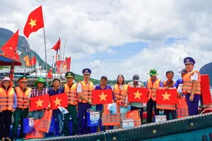 Officers and soldiers from the Coast Guard Region 3 Command, together with other delegates, present national flags and essential supplies to fishermen in Con Dao. (Photo: SGGP)
