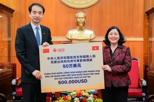 President of the Vietnam Fatherland Front Central Committee Bui Thi Minh Hoai receives US$500,000 from Chinese Government. (Photo: SGGP)