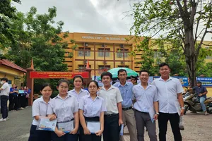 Thí sinh Trần Tiến Phước (thứ 2 từ phải qua) tại điểm thi THPT Tạ Quang Bửu vào sáng 26-6