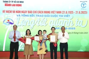 Các đồng chí Trương Hòa Bình (bìa phải) và Nguyễn Hồ Hải (bìa trái) trao giải đặc biệt cho các tác giả