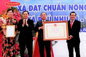 Chủ tịch UBND tỉnh Bến Tre Trần Ngọc Tam (bên trái, thứ 2) trao bằng công nhận xã nông thôn mới nâng cao cho lãnh đạo xã Phú Nhuận