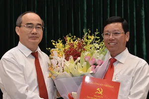 Bí thư Thành ủy TPHCM Nguyễn Thiện Nhân trao quyết định cho đồng chí Vũ Ngọc Tuất. Ảnh: VIỆT DŨNG