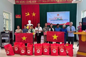 Phó Trưởng Ban Thường trực Ban Dân vận Thành ủy TPHCM Nguyễn Thị Bạch Mai trao quà và cờ Tổ quốc đến bà con