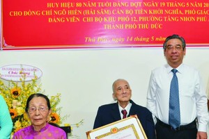 市委副书记阮福禄代表向吴宪副教授颁授80年党龄纪念章。左一是阮氏幸大娘。