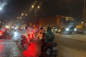 摩托车在1号国道上不顾牵引车、卡车而逆向行驶。