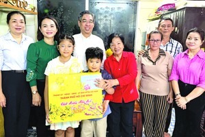 市委副书记、市越南祖国阵线委员会主席阮福禄（左四）探望家住第三郡的新冠孤儿武黄玉芝并赠送春节关怀礼物。