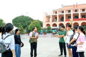 阮俊英老师(手捧书)与学生们参观芽龙码头。