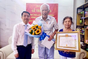 第五郡郡委代表向陆进义老先生（中）颁发60年党龄纪念章。