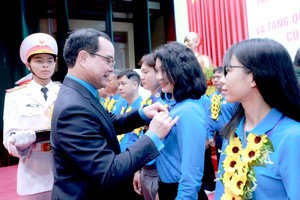 越南劳动总联团主席阮廷康给是模范工人-劳工的党员戴上胡伯伯徽章。