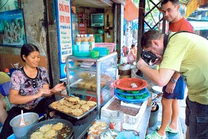 外国游客在了解越南街头美食。