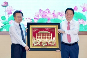 市委常务副书记阮青毅向中央宣教与民运部长阮仲义赠送纪念品。