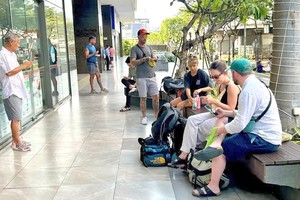 游客在第四郡第九坊云屯街River Gate 公寓大楼等候领取住房钥匙入住（尽管这里有禁止短期入住的标志）。