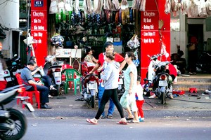 由于人行道被占用作为修车处，所以行人须在街上行走。