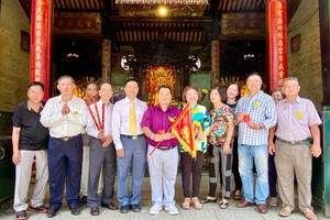 穗城会馆副理事长陈志豪将圣母令旗郑重移交予粤剧团顾问会会长丁文森后合照。