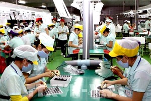 工人在广义省福斯特电子零件厂的电子元件生产流水线工作。